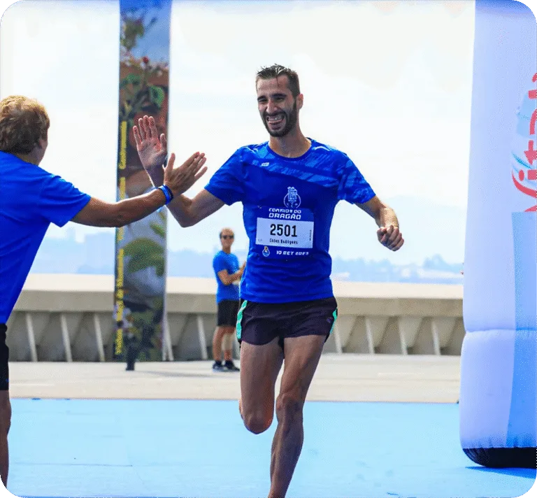 Homem recebe o cumprimento durante a corrida, batendo sua mão na mão de alguém da plateia.