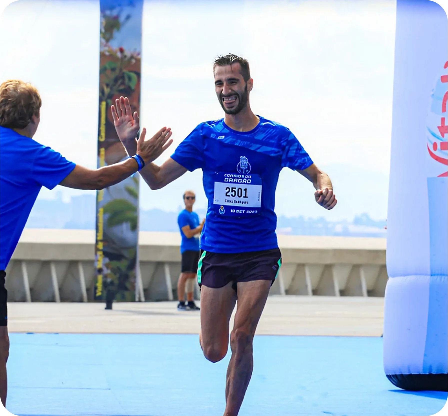 Homem recebe o cumprimento durante a corrida, batendo sua mão na mão de alguém da plateia.
